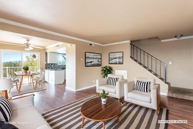 a living room with furniture and a dining table with wooden floor