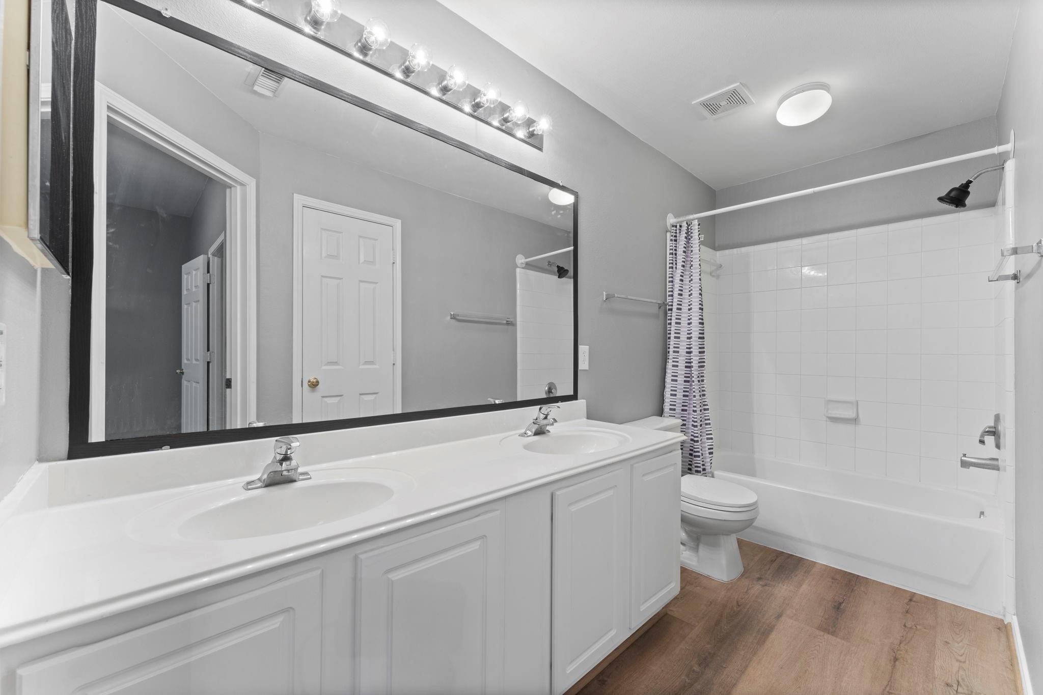 7 Verbena Bend Place Spring, TX 77382 - Photo 17 of 33 a bathroom with a double vanity sink a mirror and a bathtub