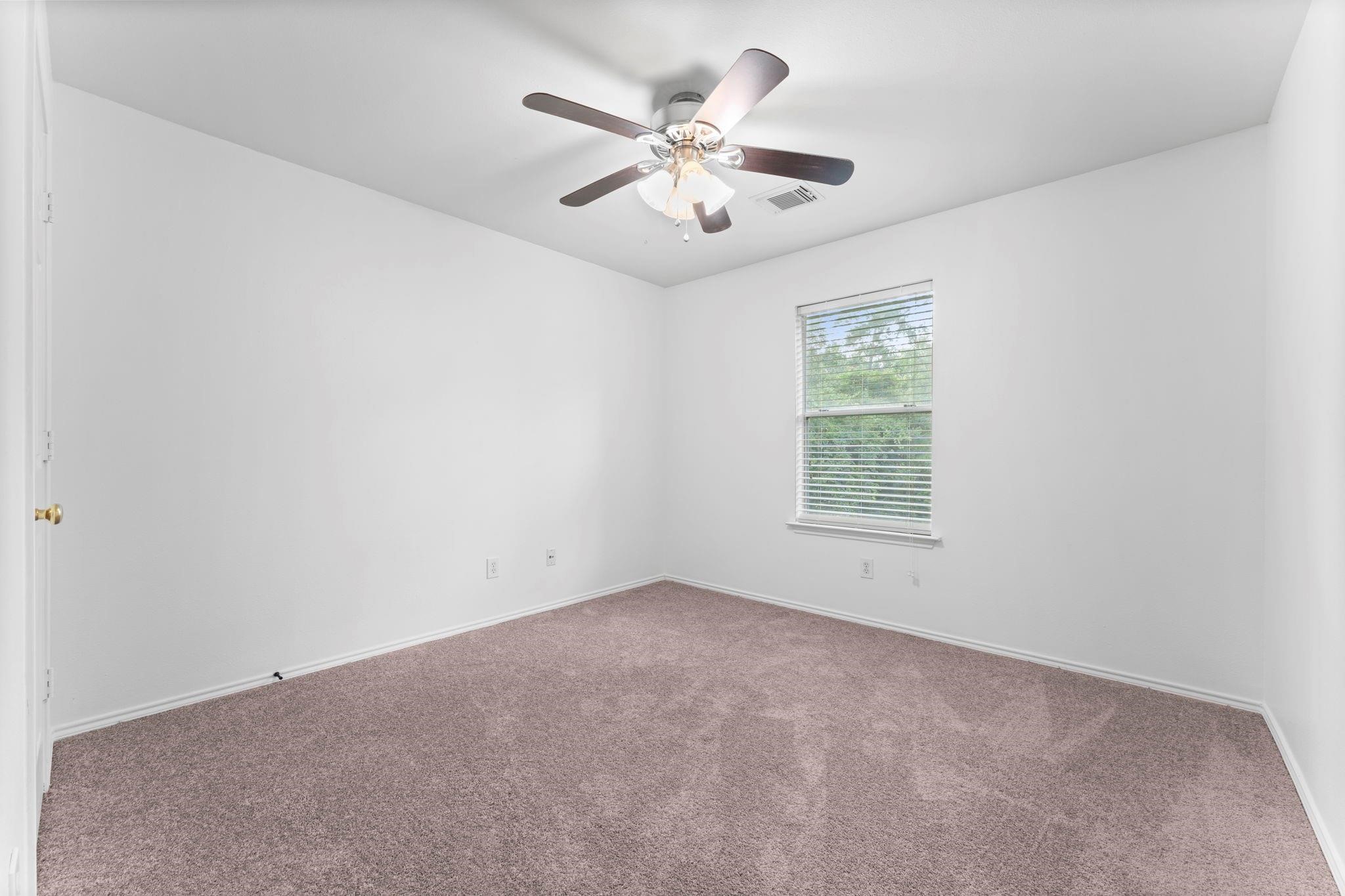 7 Verbena Bend Place Spring, TX 77382 - Photo 19 of 33 an empty room with ceiling fan and window