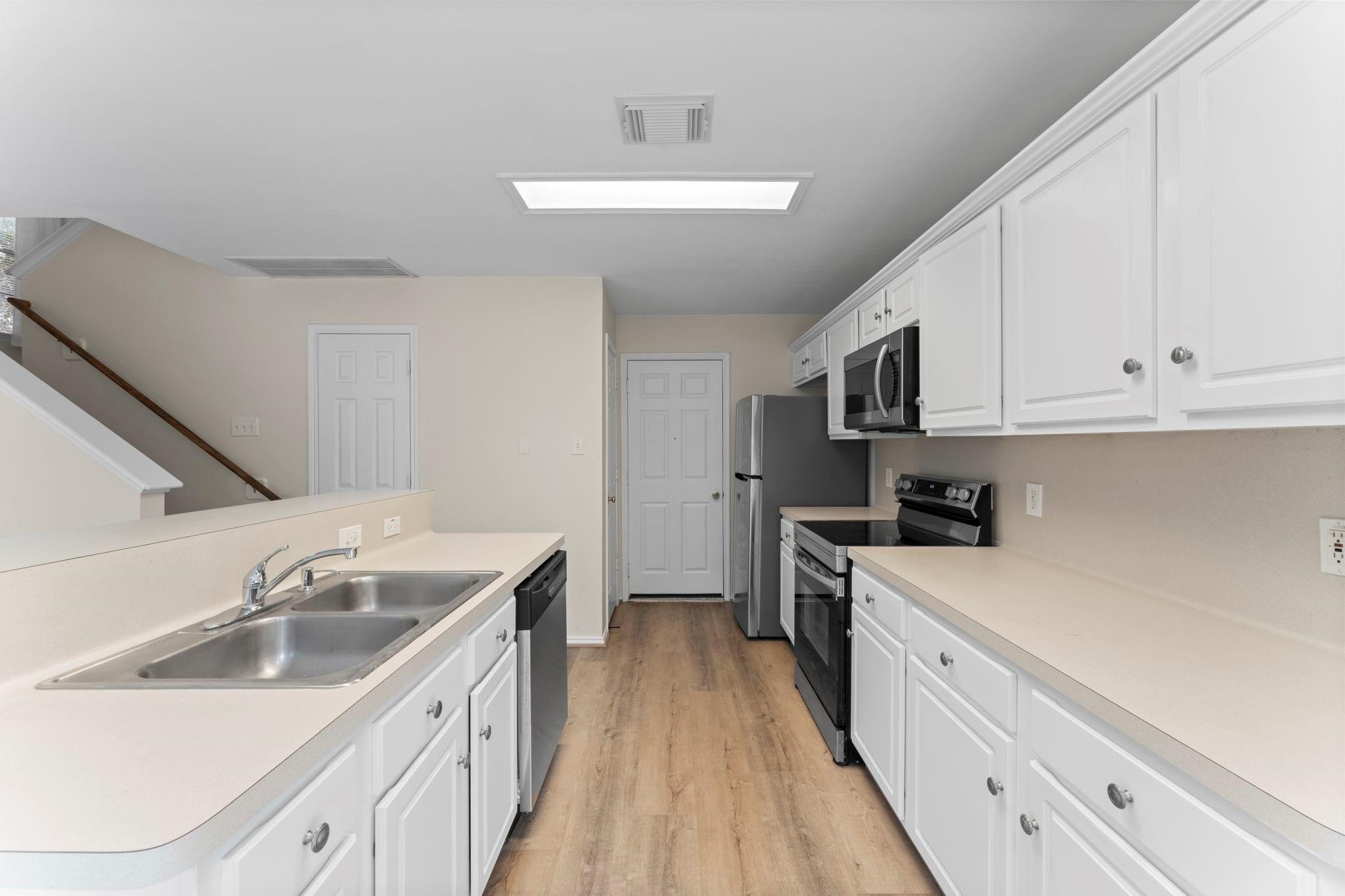7 Verbena Bend Place Spring, TX 77382 - Photo 3 of 33 a kitchen with a sink stove and cabinets