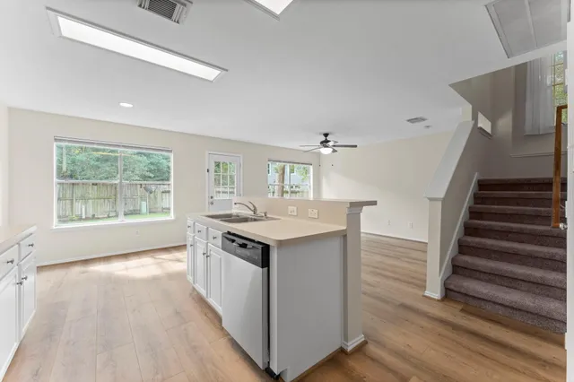 a kitchen with wooden floor and electronic appliances