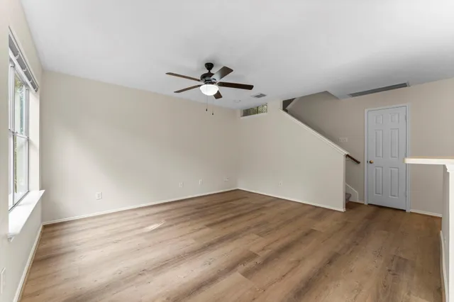 a view of a room with wooden floor and ceiling fan