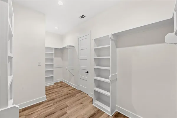 a view of walk in closet with empty racks