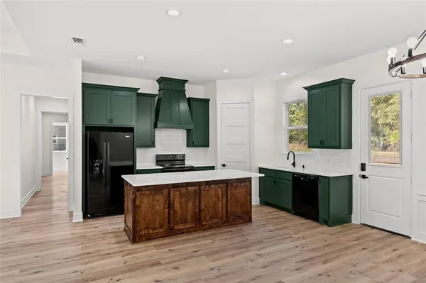 a large kitchen with a sink and stainless steel appliances