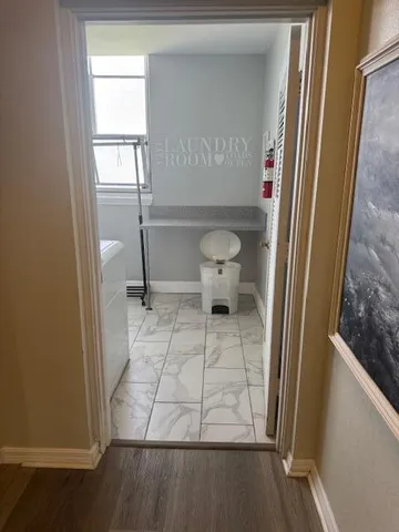 a view of a small space with wooden floor and a window