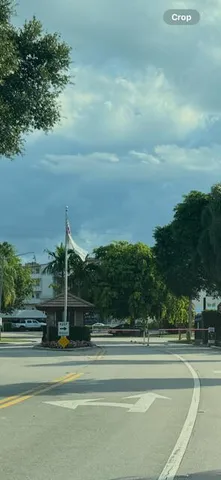 a view of a building with a big yard and large trees