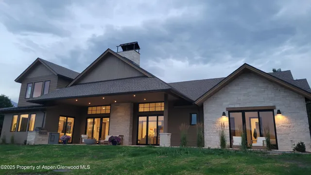 a front view of a house with a yard and a trees