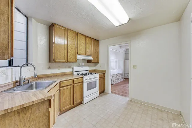 a kitchen with a sink stove and cabinets