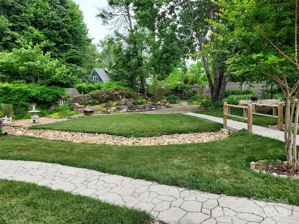 a front view of a house with a yard and potted plants