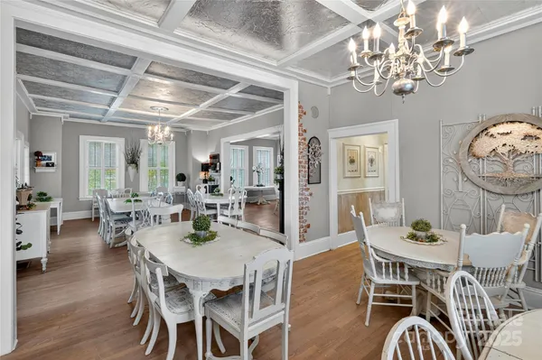 a view of a dining room with furniture a chandelier and wooden floor
