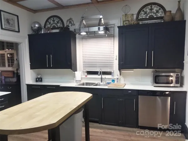 a kitchen with a sink cabinets and wooden floor