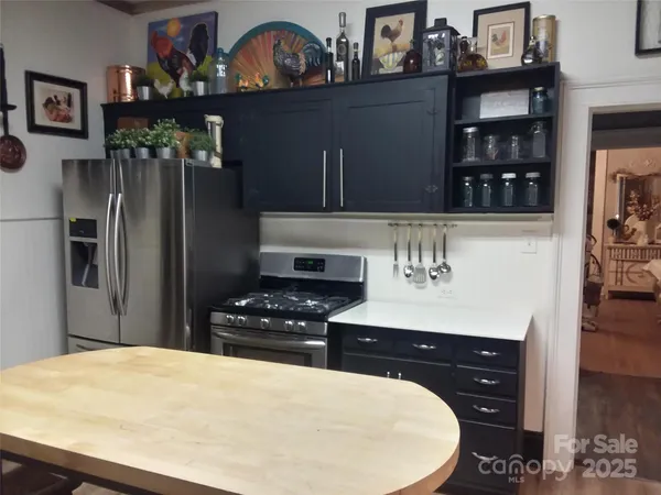 a kitchen with stainless steel appliances a stove a refrigerator and cabinets