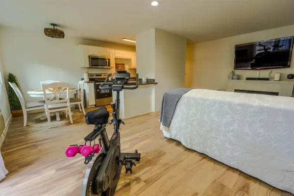 a bedroom with a bed a flat screen tv and dresser