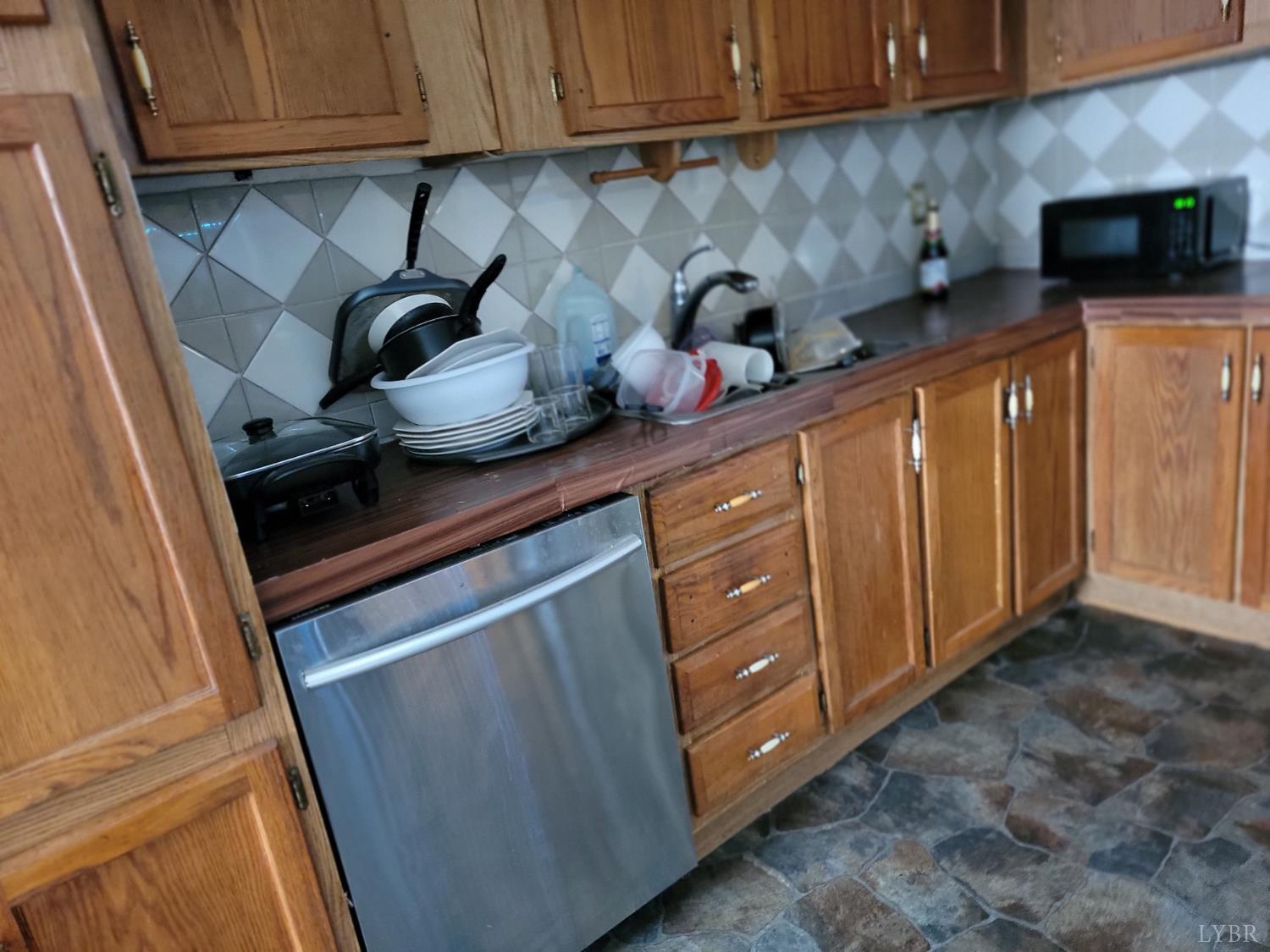 6097 Wards Road Hurt, VA 24563 - Photo 3 of 7 a kitchen with stainless steel appliances granite countertop a sink a stove cabinets and a microwave oven