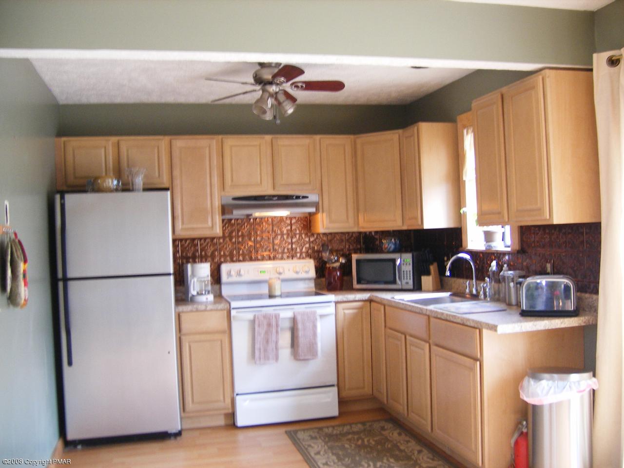 112 Bromley Road Henryville, PA 18332 - Photo 7 of 13 a kitchen with a refrigerator a stove a sink and cabinets