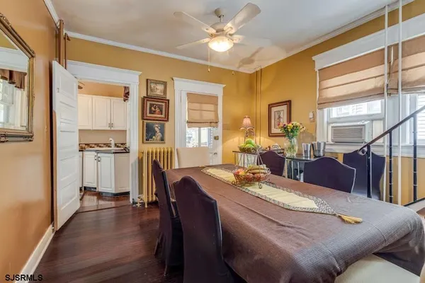 a living room with furniture dining table and a refrigerator