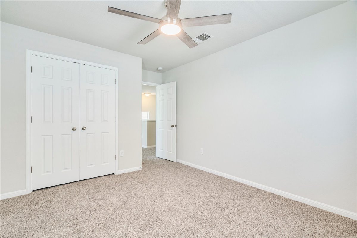 312 Triumph Road Buda, TX 78610 - Photo 27 of 36 an empty room with closet and a ceiling fan