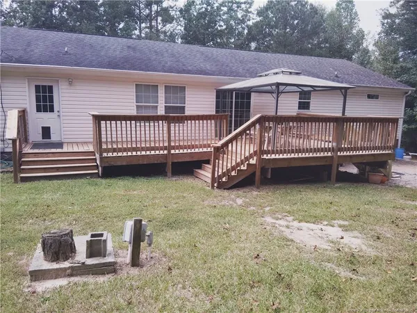 a view of a house with a yard and deck
