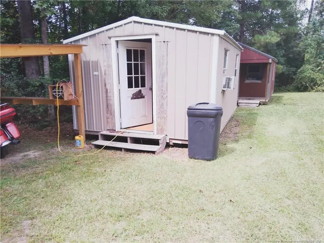 a view of a small house with backyard