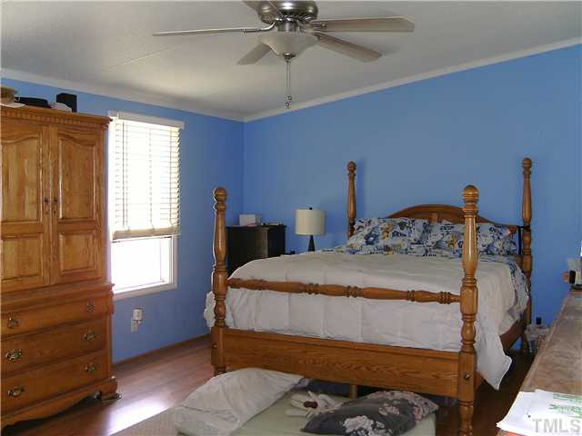 460 Club Pond Road Henderson, NC 27537 - Photo 8 of 14 Master bedroom with laminate floors and ceiling fan.
