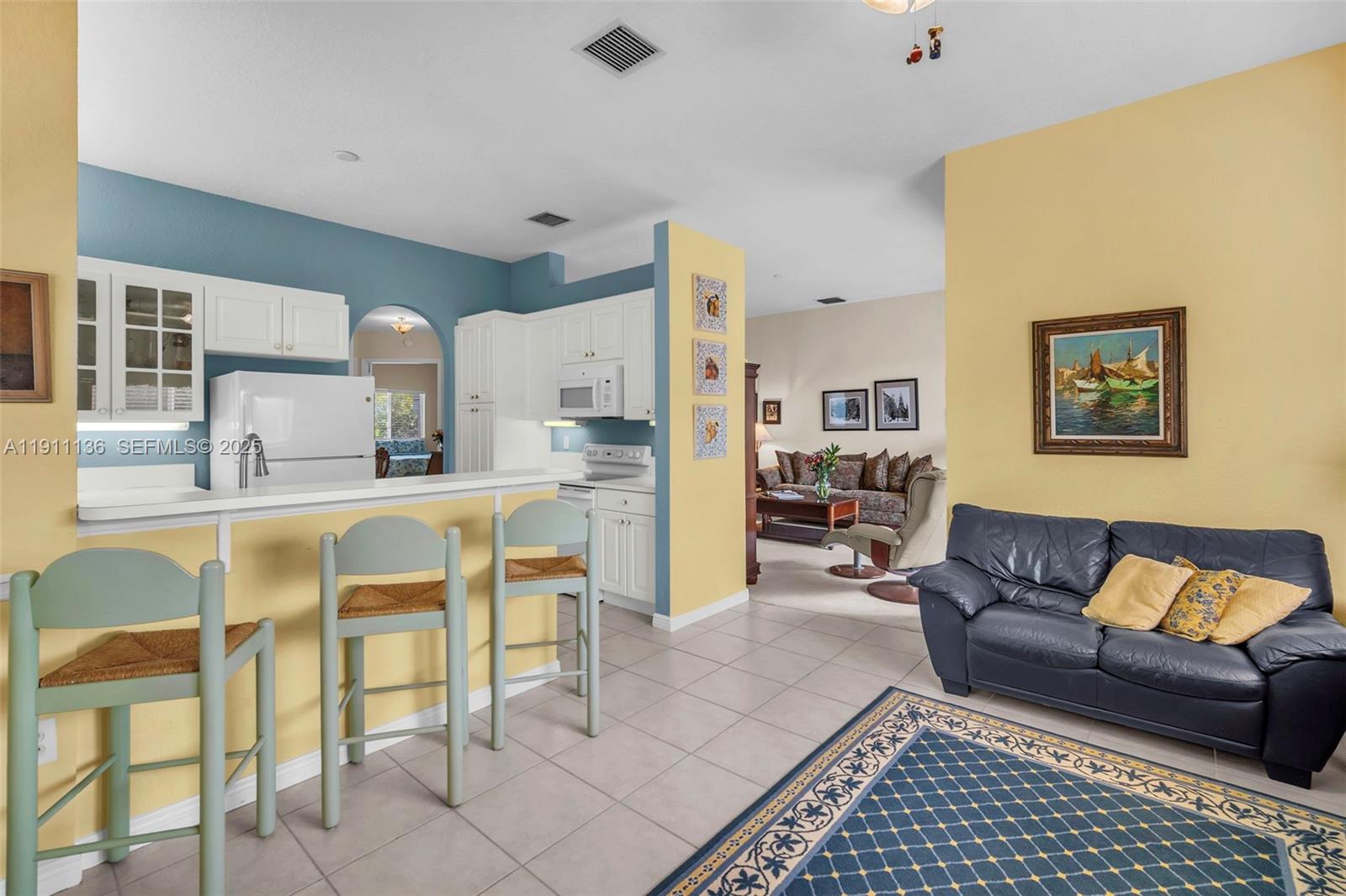 7921 Exeter Boulevard East, Unit 202 Tamarac, FL 33321 - Photo 11 of 55 a living room with furniture and a table