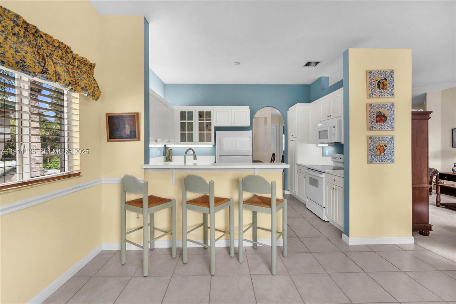 7921 Exeter Boulevard East, Unit 202 Tamarac, FL 33321 - Photo 12 of 55 a kitchen with stainless steel appliances kitchen island granite countertop a refrigerator and cabinets