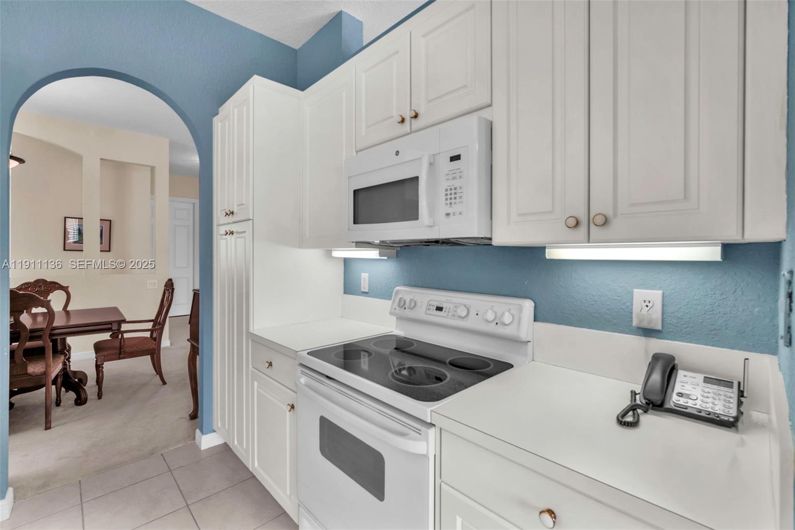 7921 Exeter Boulevard East, Unit 202 Tamarac, FL 33321 - Photo 17 of 55 a kitchen with cabinets appliances and a counter space