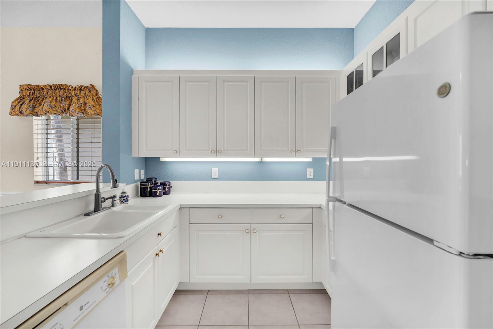 7921 Exeter Boulevard East, Unit 202 Tamarac, FL 33321 - Photo 20 of 55 a kitchen with a sink cabinets and window