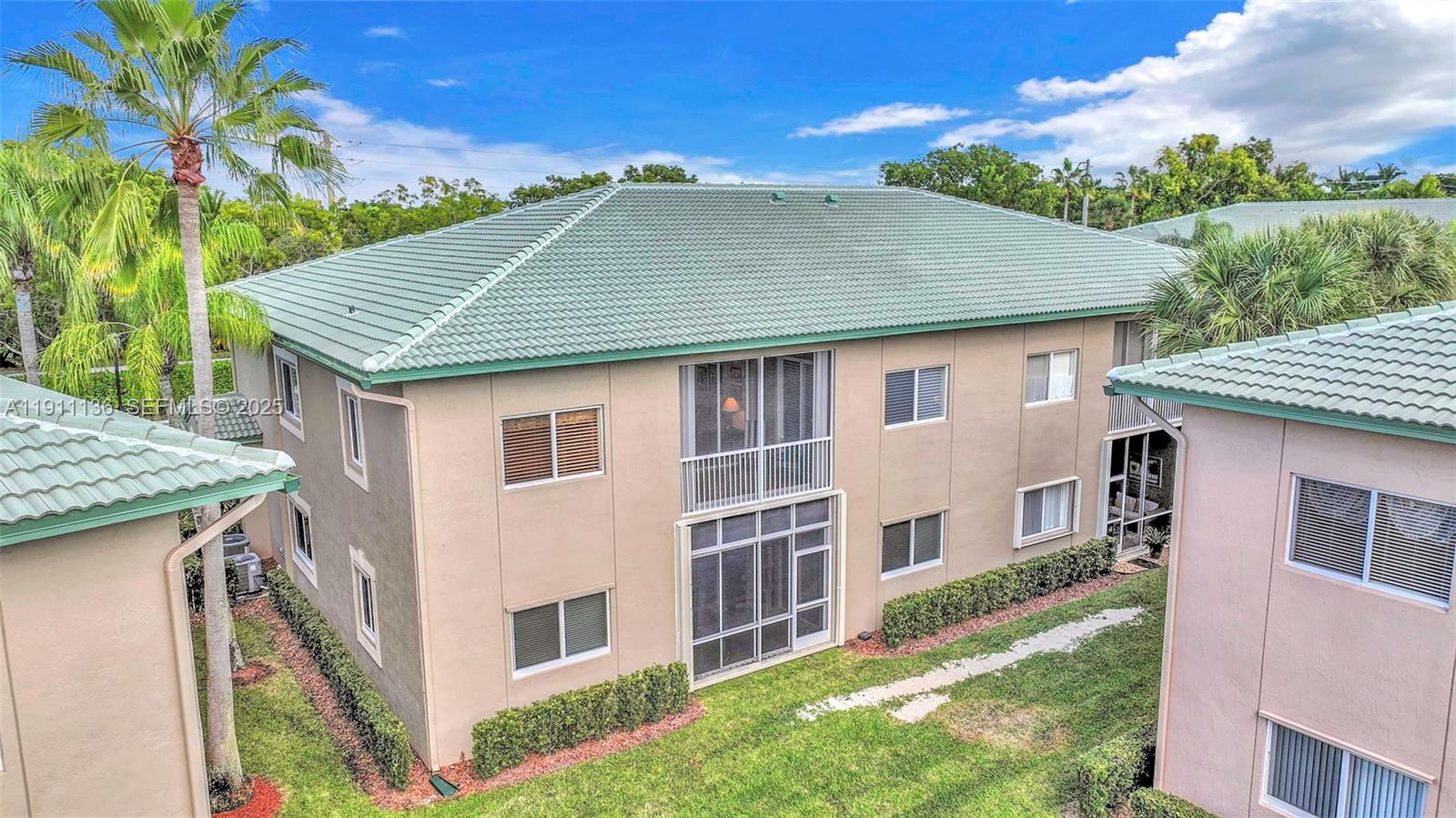 7921 Exeter Boulevard East, Unit 202 Tamarac, FL 33321 - Photo 2 of 55 a front view of a house with a garden