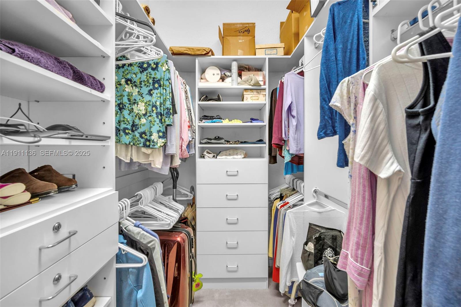 7921 Exeter Boulevard East, Unit 202 Tamarac, FL 33321 - Photo 25 of 55 a view of walk in closet with clothes and shoes