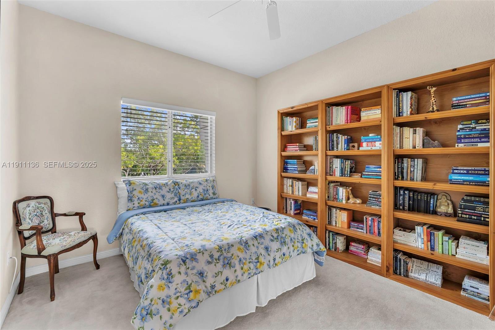 7921 Exeter Boulevard East, Unit 202 Tamarac, FL 33321 - Photo 30 of 55 a bedroom with a bed a book shelf and a window