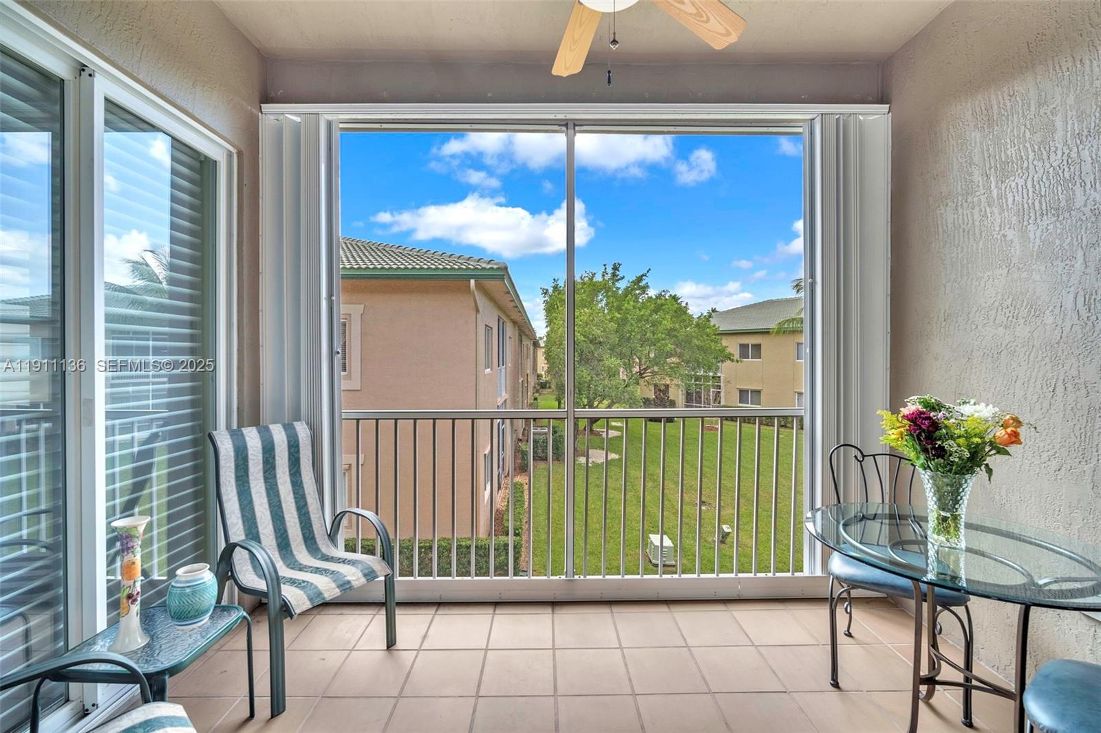 7921 Exeter Boulevard East, Unit 202 Tamarac, FL 33321 - Photo 32 of 55 a view of a porch with a table and chairs