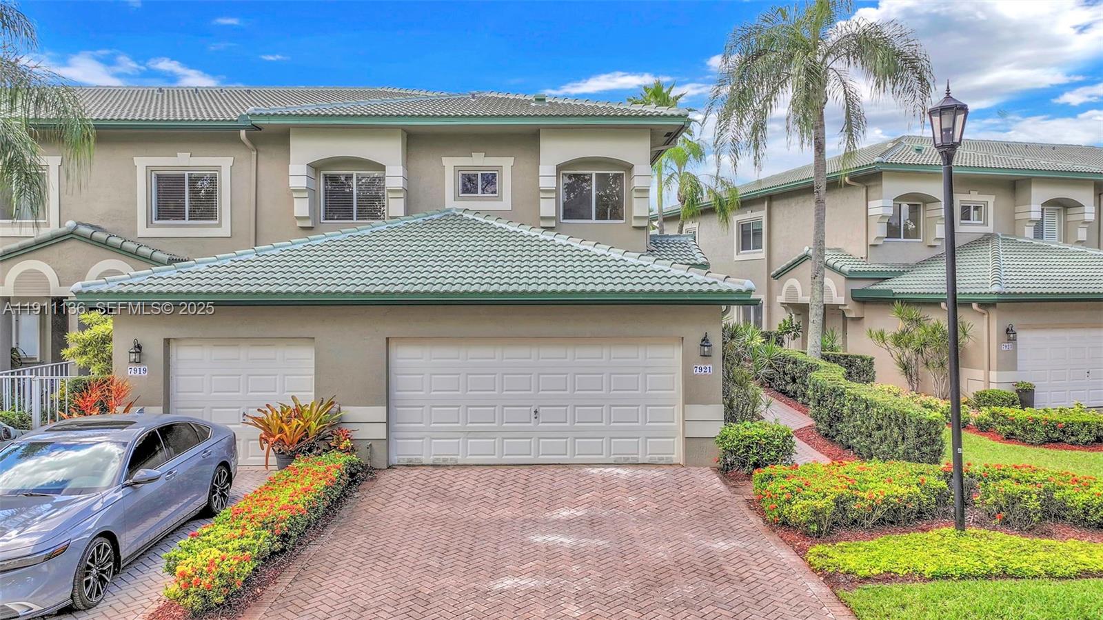 7921 Exeter Boulevard East, Unit 202 Tamarac, FL 33321 - Photo 33 of 55 a front view of a house with a garden and outdoor seating