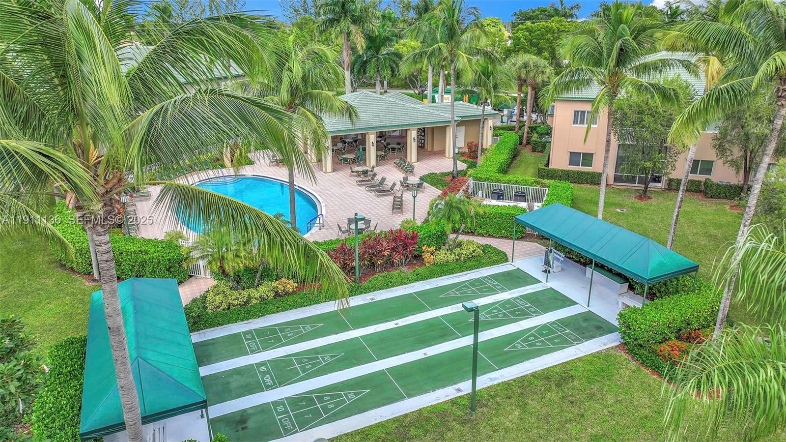 7921 Exeter Boulevard East, Unit 202 Tamarac, FL 33321 - Photo 40 of 55 a front view of a house with a yard table and chairs