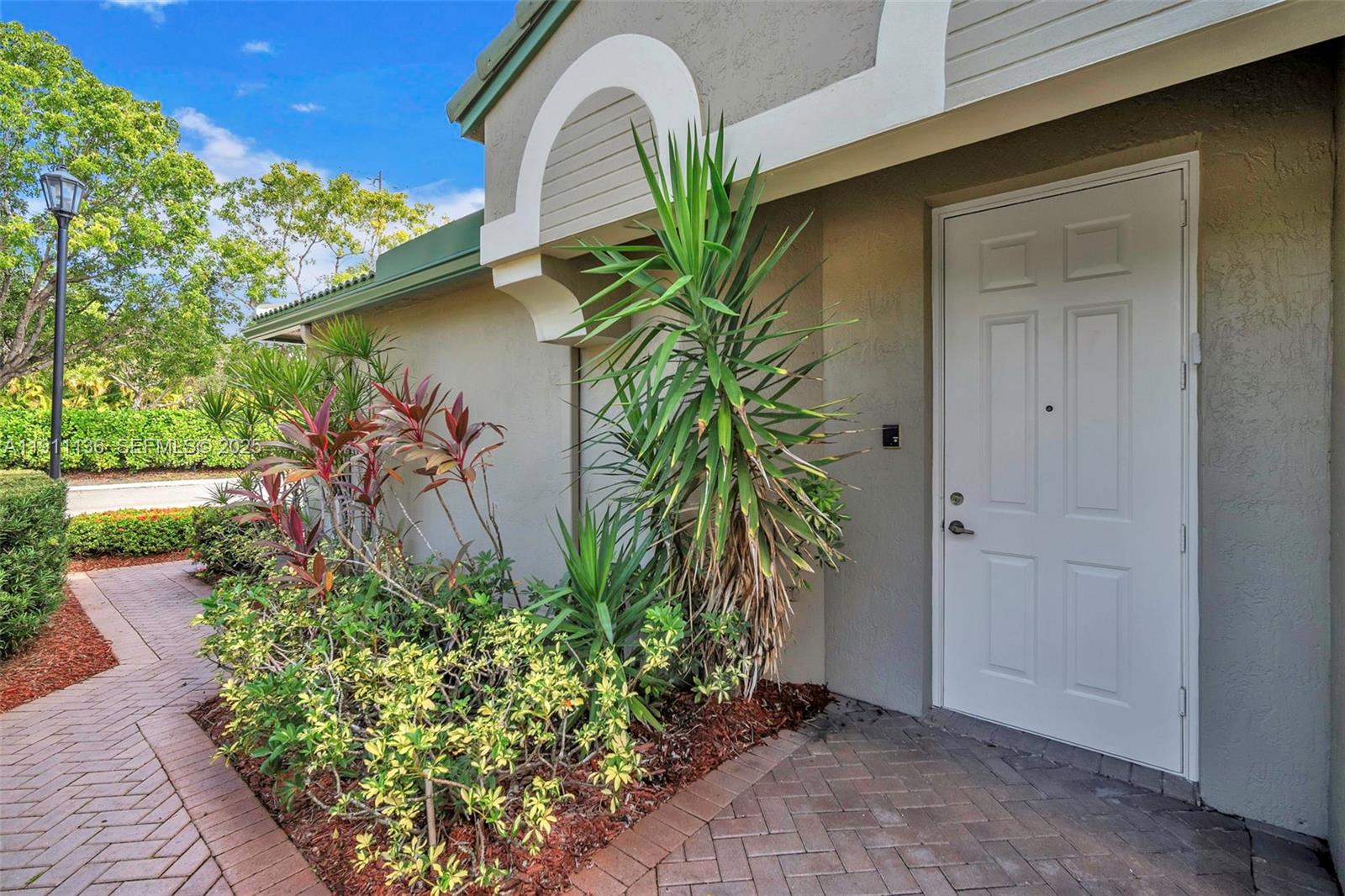7921 Exeter Boulevard East, Unit 202 Tamarac, FL 33321 - Photo 43 of 55 a house with a flower garden in front of it