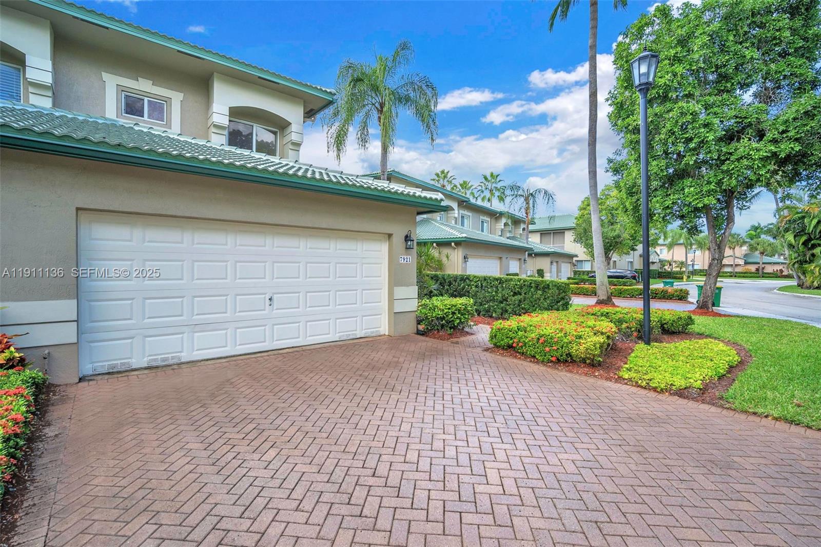 7921 Exeter Boulevard East, Unit 202 Tamarac, FL 33321 - Photo 46 of 55 a front view of a house with a yard and garage