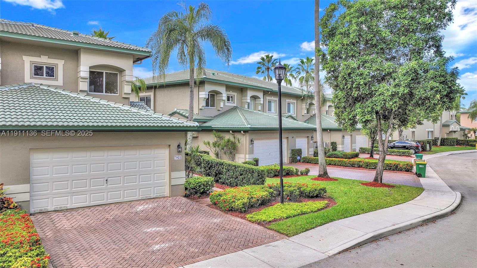 7921 Exeter Boulevard East, Unit 202 Tamarac, FL 33321 - Photo 49 of 55 a front view of a house with a garden and plants