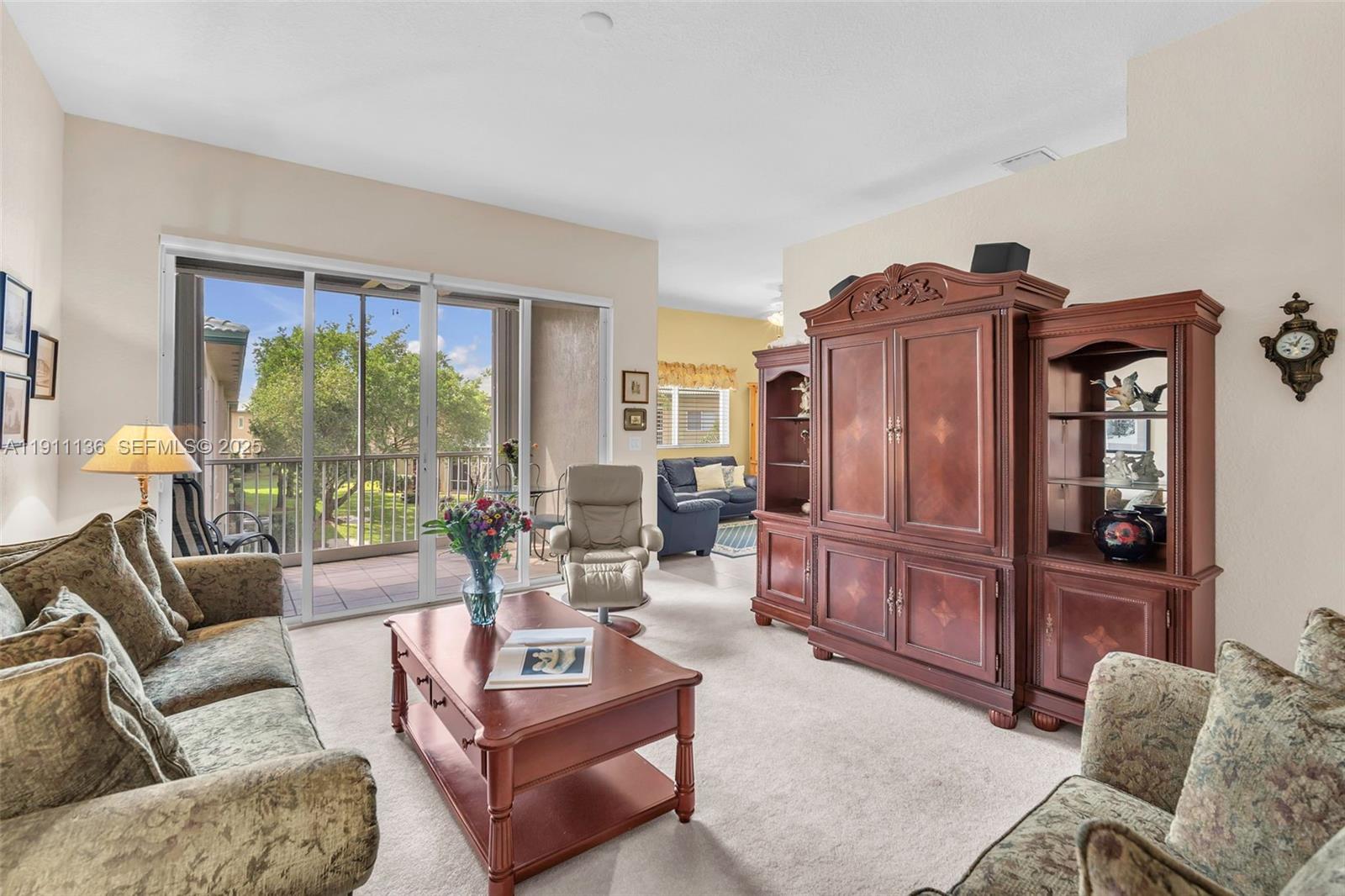 7921 Exeter Boulevard East, Unit 202 Tamarac, FL 33321 - Photo 8 of 55 a living room with furniture and a floor to ceiling window