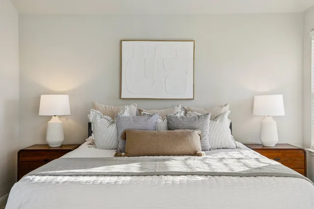 a large bed sitting in a bedroom next to a lamp