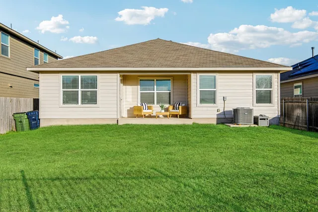a front view of house with yard barbeque and outdoor seating