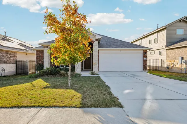 a white house that has tree in front of it