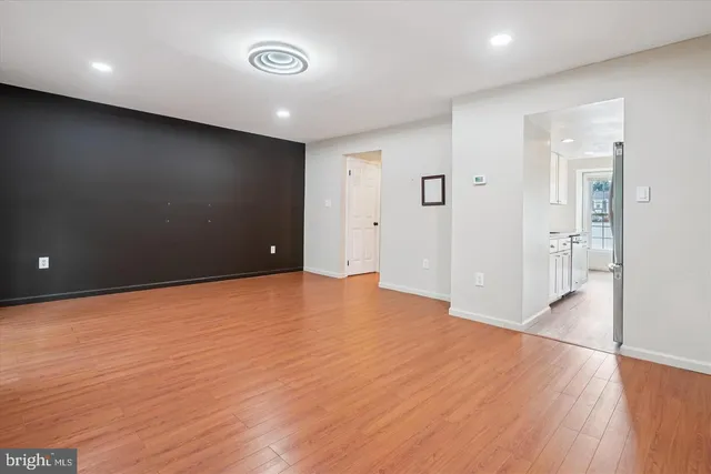 a view of empty room with wooden floor