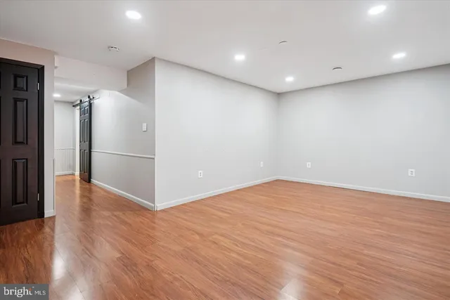 a view of empty room with wooden floor and electronic appliances