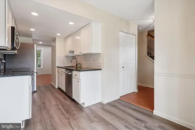 a kitchen with stainless steel appliances granite countertop a refrigerator a sink and a stove