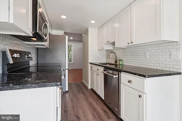 a kitchen with stainless steel appliances granite countertop a sink and a stove