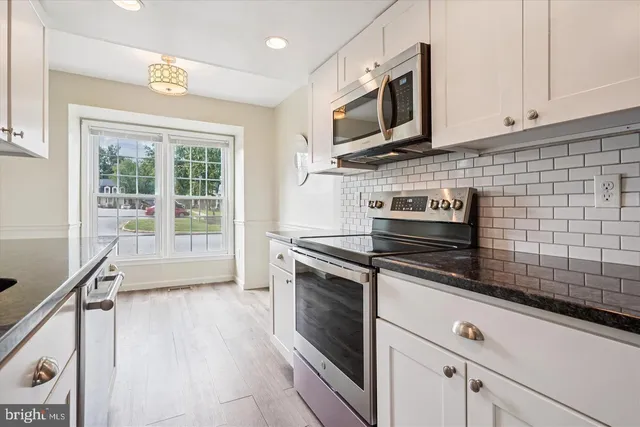 a kitchen with stainless steel appliances a stove sink and microwave