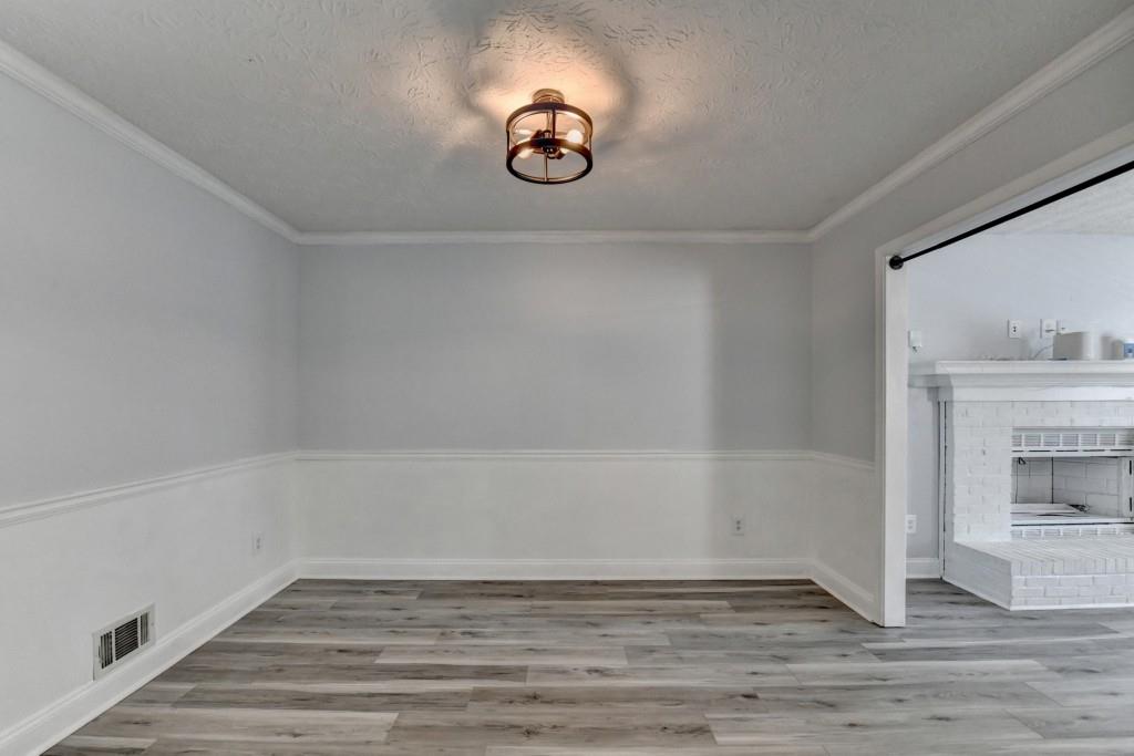 351 Cottonpatch Road Lawrenceville, GA 30046 - Photo 11 of 47 a view of an empty room with a fireplace and wooden floor
