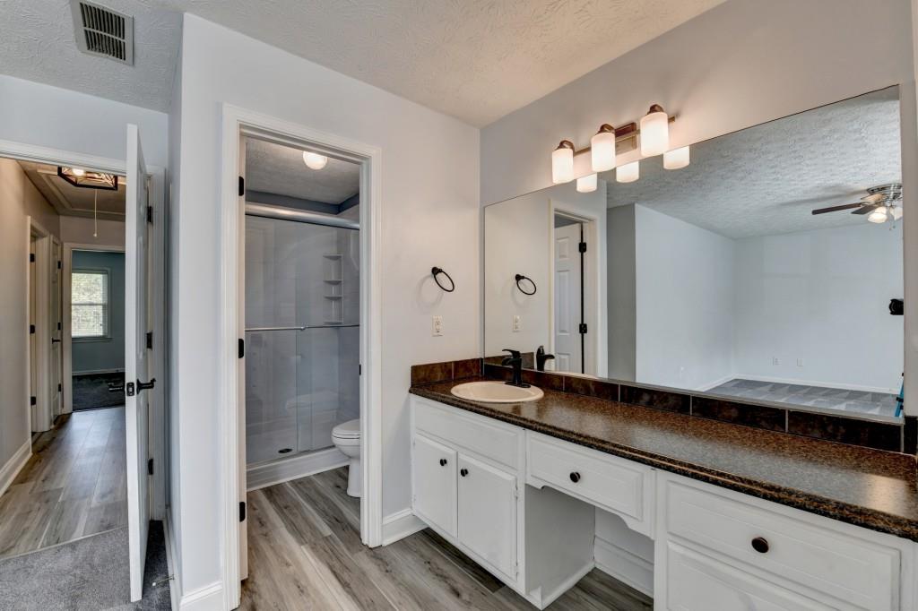 351 Cottonpatch Road Lawrenceville, GA 30046 - Photo 23 of 47 a spacious bathroom with a granite countertop sink a mirror and shower