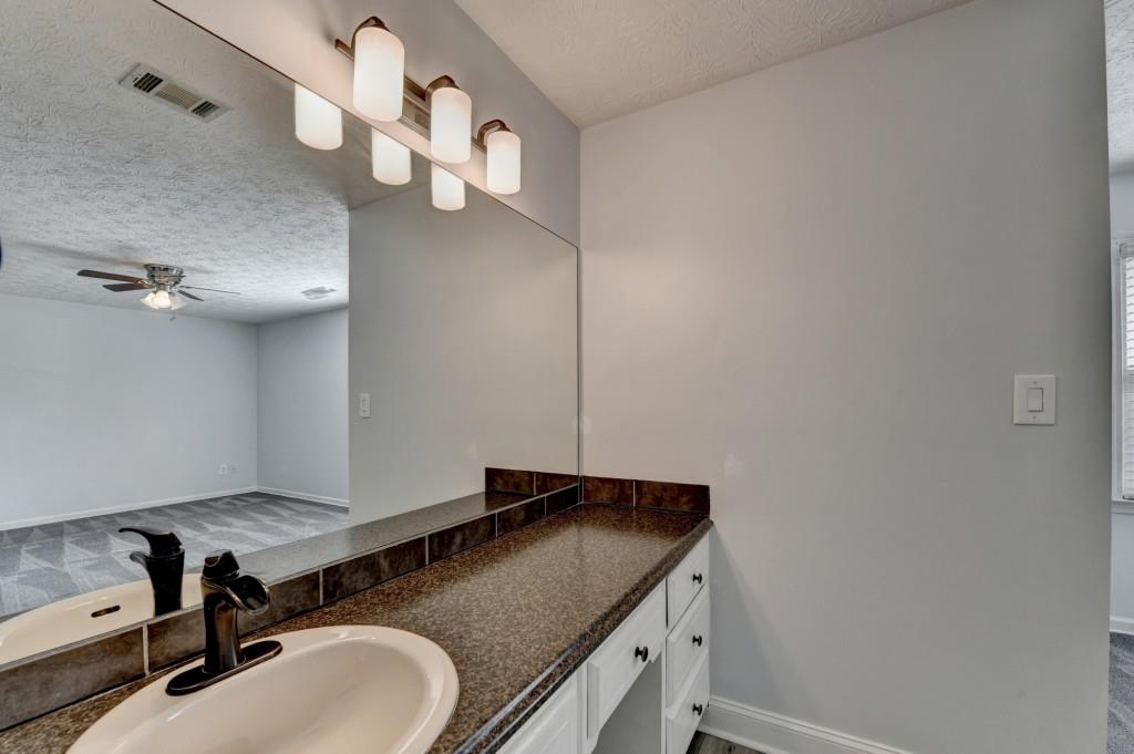 351 Cottonpatch Road Lawrenceville, GA 30046 - Photo 25 of 47 a bathroom with a granite countertop sink and a mirror