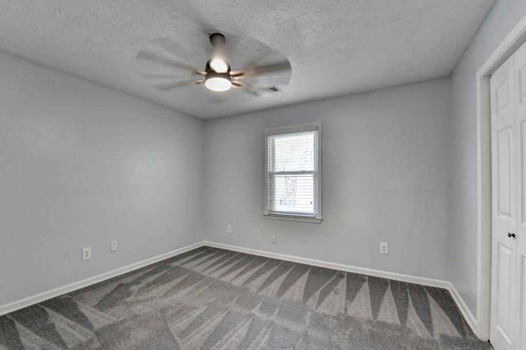 351 Cottonpatch Road Lawrenceville, GA 30046 - Photo 26 of 47 an empty room with chandelier fan and windows